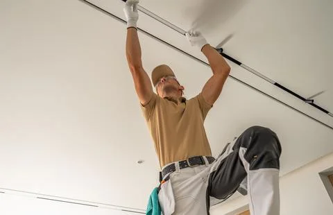 Worker installing a ceiling curtain track Stock Photos