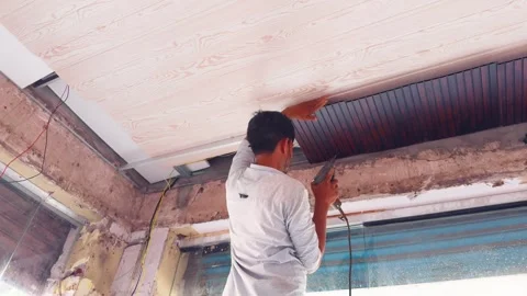 Worker Installing Ceiling Panel in Renovated Shop Stock Footage 313277687