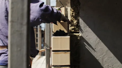 Worker installing ceramic facade tiles on building wall Stock Footage 314235419