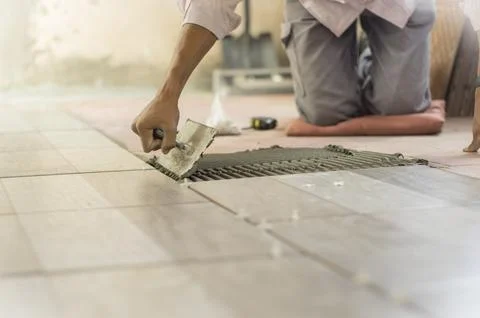 Worker installing a ceramic floor 写真素材