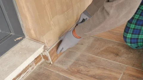 Worker Installing Ceramic Skirting Tiles on Wall Stock Footage 340178668