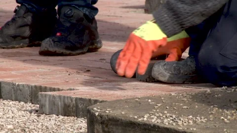 Worker installing concrete brick pavement using hammer Video stock 234132561