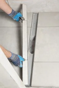 A worker is installing a drain lid. Stock Photos