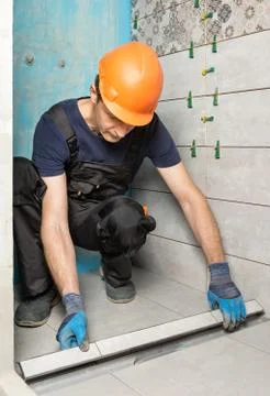 The worker is installing a drain lid. Stock Photos