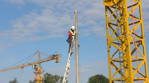Worker Installing Electrical Cables on Concrete Utility Pole Wearing PPE Stock Footage 332835304