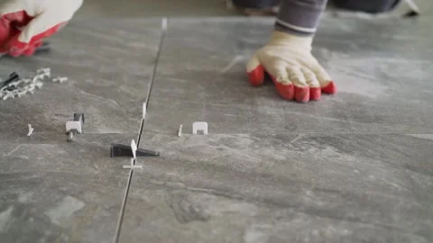 Worker Installing Floor Tiles with Leveling System Stock Footage 331473519