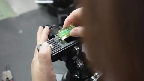 Worker installing green spirit bubble level onto black telescope equatorial Stock Footage 334964387