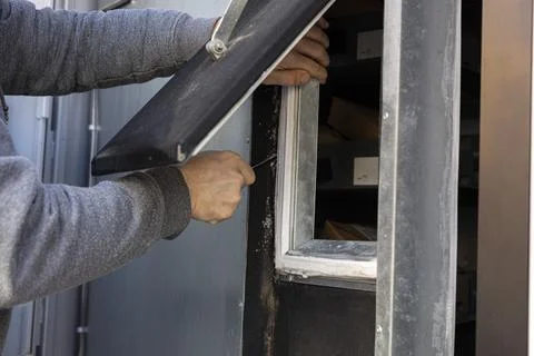 Worker installing insulation on vehicle window frame Stock Photos