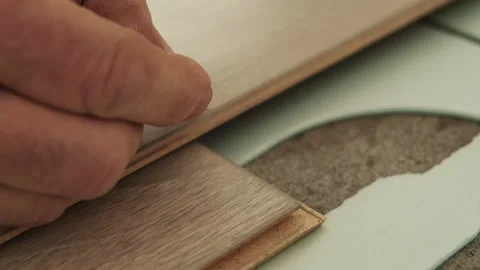 Worker Installing Laminate Plank on Floor Underlayment Stock Footage 322055206