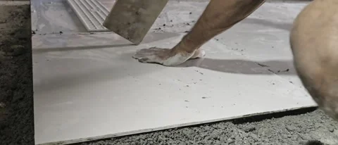 Worker Installing Large Format Ceramic Floor Tile on Wet Cement Mortar Stock Footage 341715393