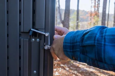 Worker installing a metal gate at shed in backyard Stock Photos