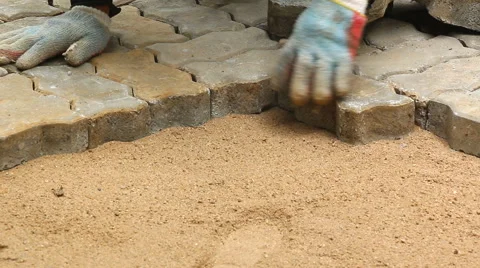 Worker installing old cobblestone block for build floor ground Stock Footage 42613685