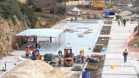 Worker installing old cobblestone block for build floor ground Stockbeeldmateriaal 86885988