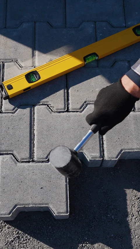 Worker Installing Paving Slabs with Hammer Stock-Footage 297787399