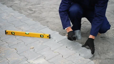 Worker installing paving stones with mallet and level tool Stock-Footage 300894503