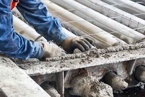 Worker installing reinforcement into form of floor slabs Stock Photos