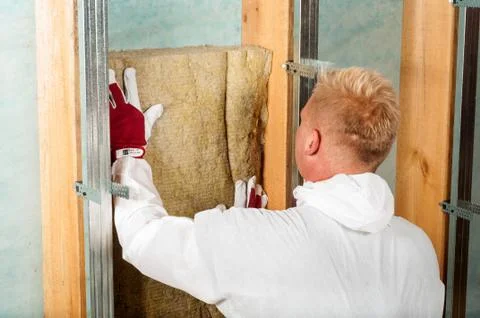 Worker installing rockwool for home attic insulation Stock Photos