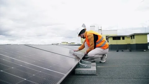 Worker installing rooftop solar panels with level. Vídeo Stock 331299339