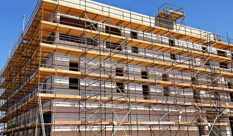 Worker installing scaffolding on building, showcasing the teamwork and safe.. 스톡 사진