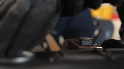 Worker installing securing bolt and washer with metal ring in industrial setting Stock Footage 313815346