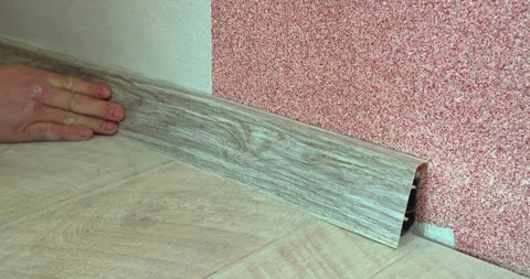 A worker installing a skirting board during repairs Video stock 309109485