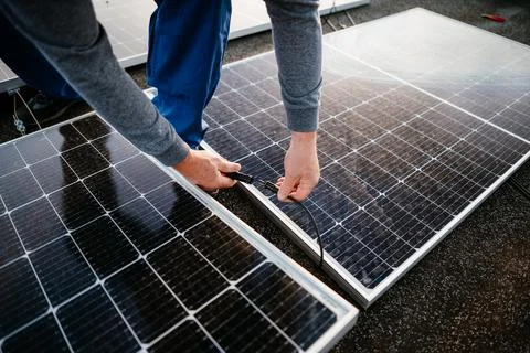 Worker installing solar energy panels. connect two panel together. eco concept Fotos Stock