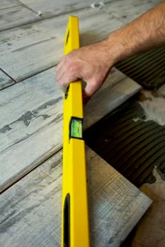 Worker installing Tiles on the Floor Stock Photos