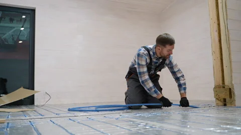 Worker installing underfloor heating in modular home Stock Footage 301825145