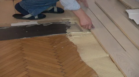 Worker installing wood floor parquet board Stock Footage 32639003