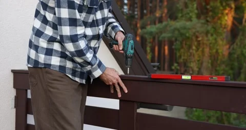 Worker installing wooden balcony railing with screwdriver during house cons.. Stock Footage 344873609