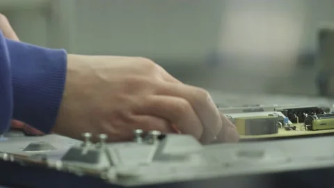 Worker installs an electronic board on the back of a TV Stock Footage 162364508