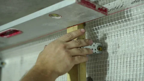 A worker installs a frame of beams and metal fasteners for installing OSB Video stock 249751260