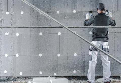 Worker Installs Insulation on Construction Site Wall Foto stock