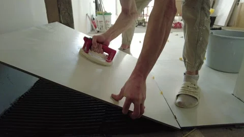 Worker installs large panel on floor during home renovation in city apartment in 스톡 동영상 332455310