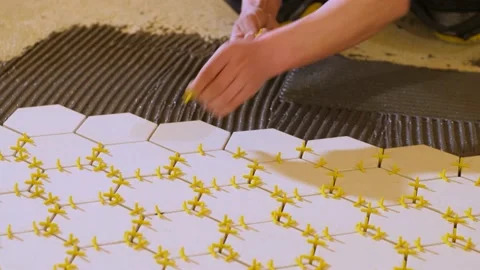 A worker installs plastic crosses between ceramic tiles. Video stock 199837825