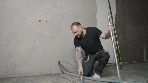 Worker installs tile using specialized tools in a modern setting Stock Footage 317380886