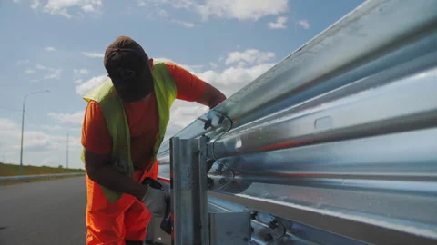 Worker installs traffic fence on freeway during roadworks Stock Footage 252916657
