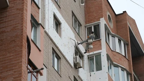Worker insulating exterior wall. Builder doing insulating work holding Stock Footage 117089357