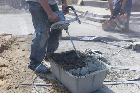 A worker interferes with cement on a construction site. Stock Photos
