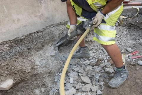 Worker with a jackhammer at the construction site Stock Photos