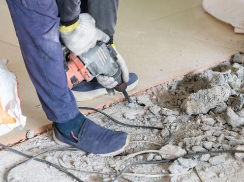 A worker is jackhammering the tile floor. Stock Photos