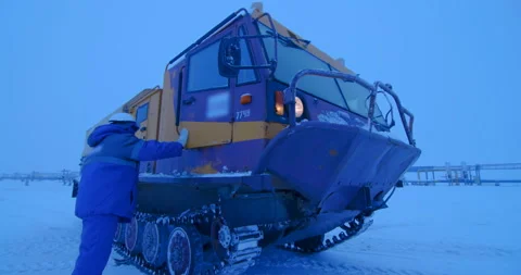 Worker  jumps from the cab of a tracked all-terrain vehicle Stock Footage 105988952