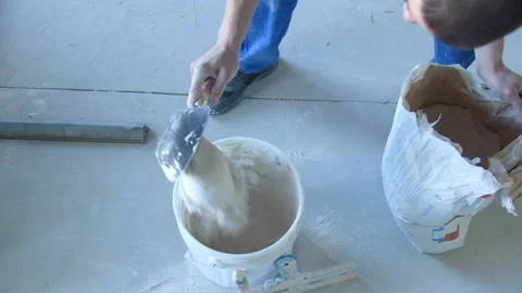 A worker kneads the mixture into plaster buckets. Stock Footage 154461100