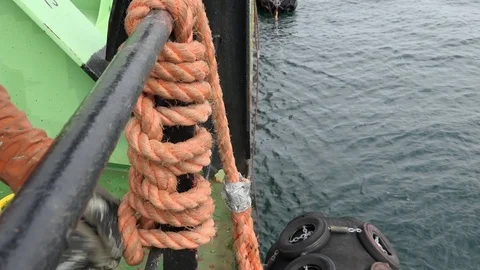 Worker knits nautical knots to attach mooring fenders Stock Footage 119034884