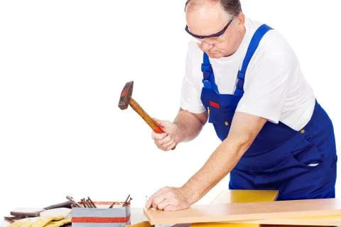 Worker knocking the nail in board Foto stock