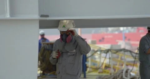 A worker at a Korean shipyard prepares to paint a ship. Stock Footage 166389461