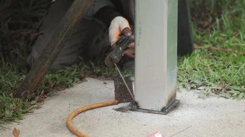Worker labor welding steel bolt nuts to metal pole. Video stock 247367531