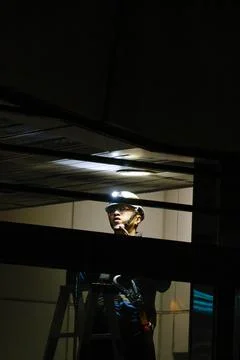 Worker on Ladder Replacing Light Fixture at Night in Taipei Metro Station Stock-Fotos