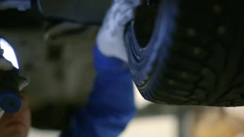 A worker with a lantern checks the wheels of the car. Stock Footage 80469945