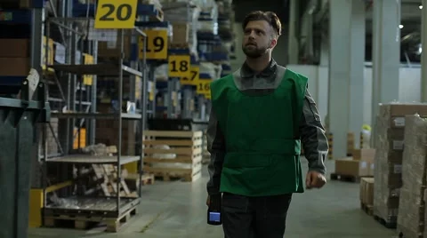 The worker is to a large warehouse with a terminal in the hand Stock Footage 64046392
